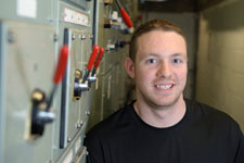 electrical engineer leaning against panel