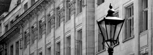 A lamp-post in front of a large building.