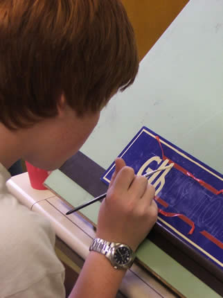 Pupil painting a sign