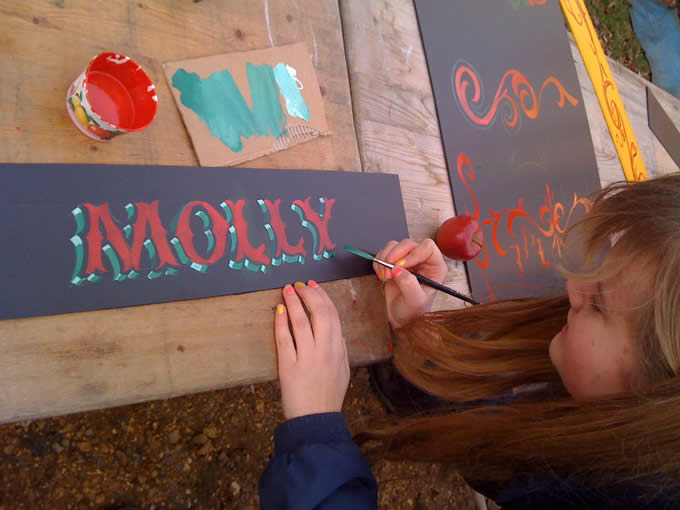 students painting lettering designs